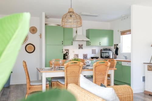 une cuisine avec des placards verts et une table avec des chaises dans l'établissement Maison de vacances avec piscine Les Sables d'Olonne 6 personnes, à Les Sables-dʼOlonne