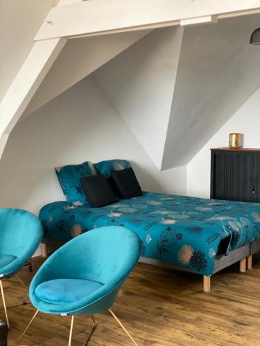 ein Schlafzimmer mit einem Bett und zwei blauen Stühlen in der Unterkunft Studio en résidence face à la mer -Sarzeau in Sarzeau