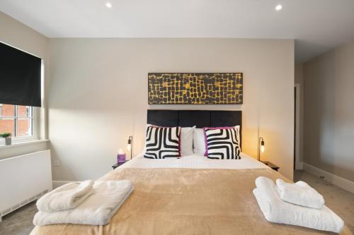 a bedroom with a large bed with two white towels at WhiskAwayStays - Victoria House - Apartment 6 in Worcester