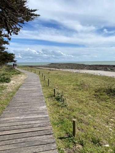 einen Holzweg zum Strand in der Unterkunft Studio en résidence face à la mer -Sarzeau in Sarzeau