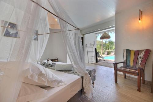 een slaapkamer met een bed met een klamboe bij Villa lEcrin in Les Trois-Îlets