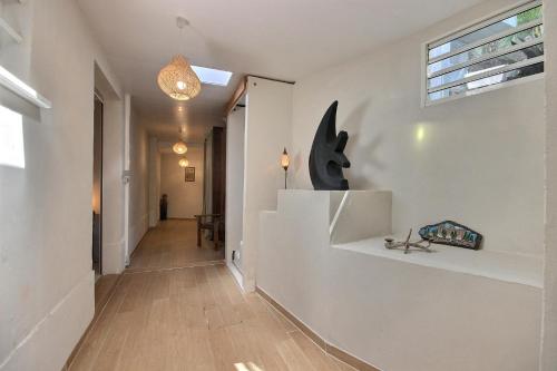 - un couloir d'une maison dotée de murs blancs et de parquet dans l'établissement Villa lEcrin, à Les Trois-Îlets