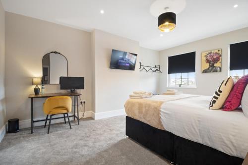 a bedroom with a bed and a desk with a computer at WhiskAwayStays - Victoria House - Apartment 6 in Worcester