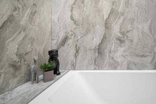 a bathroom with a white tub with a zebra and a plant at WhiskAwayStays - Victoria House - Apartment 6 in Worcester