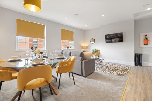 a dining room with a table and chairs and a couch at WhiskAwayStays - Victoria House - Apartment 6 in Worcester