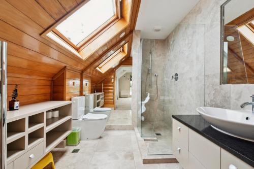 a bathroom with four toilets and a sink and a skylight at Relax at Redoubt - Auckland Holiday Home in Auckland