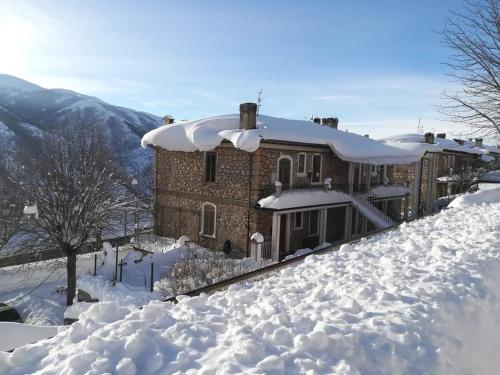 een huis bedekt met sneeuw in de sneeuw bij Casa Vacanze Frattura in Frattura