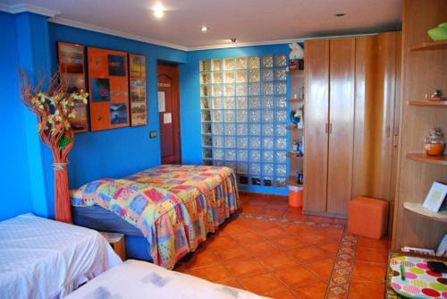 a bedroom with two beds and blue walls at Carmen - Habitación con vistas al mar in Santander