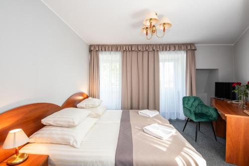 ein Hotelzimmer mit Bett, Schreibtisch und Fernseher in der Unterkunft Rewita Miedzyzdroje - MORSKIE OKO in Misdroy