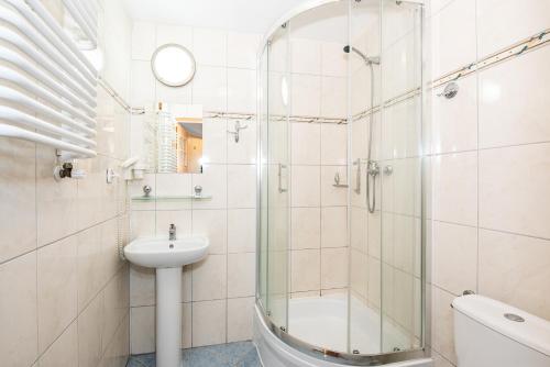 ein Badezimmer mit Glasdusche und Waschbecken in der Unterkunft Rewita Miedzyzdroje - MORSKIE OKO in Misdroy