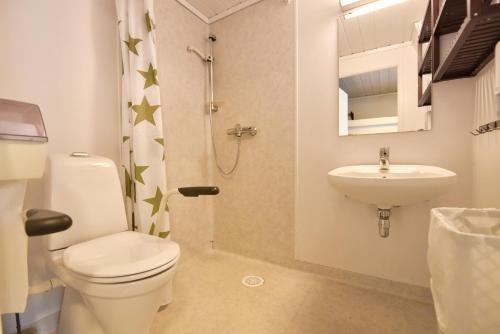 uma casa de banho com um WC e um lavatório em Evjetun em Evje