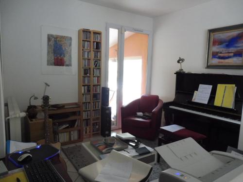 - un salon avec un piano et une chaise dans l'établissement art Lançon, à Lançon-Provence