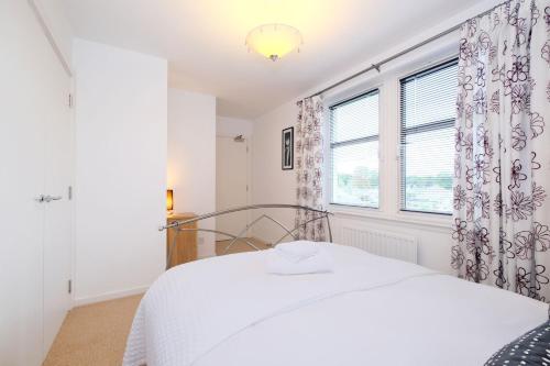 a white bedroom with a bed and a window at Lovely Aberdeen Home close to the Scottish Coast in Aberdeen