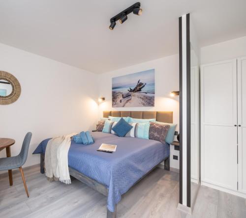 a bedroom with a blue bed and a table at Green Garden & Parking Apartments in Rīga