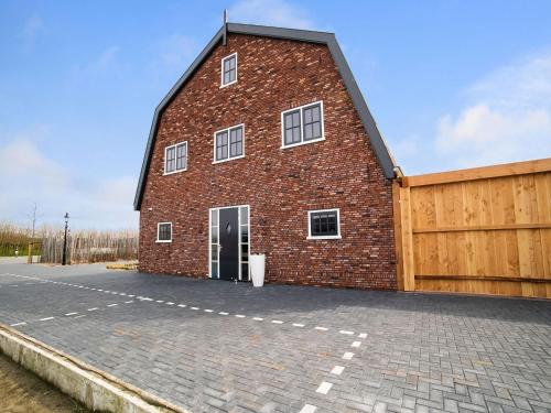 un gran edificio de ladrillo rojo con garaje en Spacious holiday home Hazenborgh in Callantsoog near beach, en Callantsoog