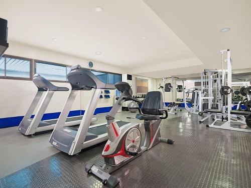 a gym with two treadmills and cardio machines at The Residences Olympia in Manila