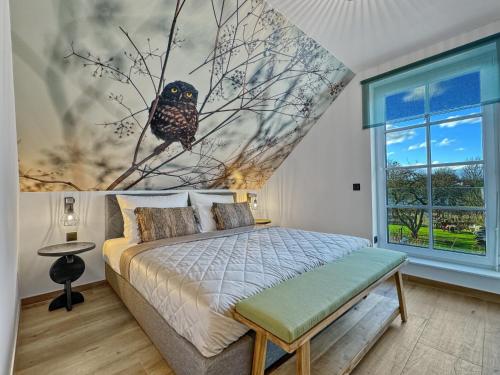 a bedroom with an owl on a tree branch mural at CBlue: Seeblick, Kamin, Wallbox, Natur in Bentwisch