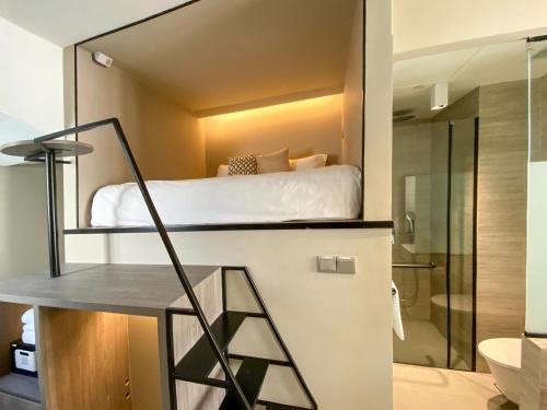 a small bedroom with a bed and a shower at ST Signature Jalan Besar in Singapore