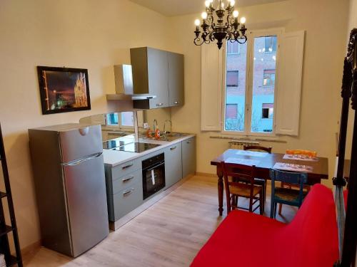 una cucina con frigorifero e tavolo con sedie di Ciclamino fori Porta Pispini 2 a Siena