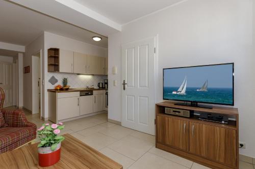 a living room with a flat screen tv at Appartementhaus Strandnähe in Warnemünde