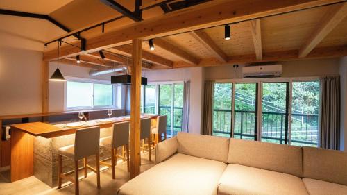 un salon avec un canapé et une cuisine avec un comptoir dans l'établissement Hotel Re:Plug, à Kōchi