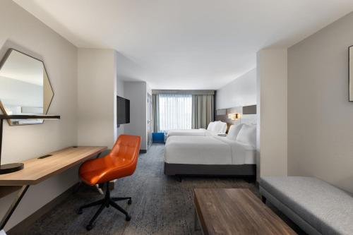 a hotel room with a desk and a bed at Holiday Inn Express Savannah Airport by IHG in Savannah