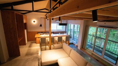 a large living room with a couch and a kitchen at Hotel Re:Plug in Kochi
