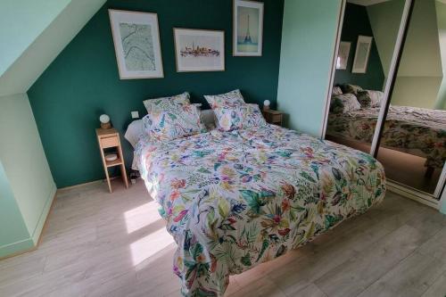 ein Schlafzimmer mit einem Bett mit einer bunten Bettdecke in der Unterkunft Calme et vue magnifique aux portes de Paris in Vaux-sur-Seine
