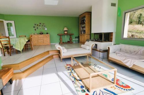 ein Wohnzimmer mit einem Sofa und einem Tisch in der Unterkunft Calme et vue magnifique aux portes de Paris in Vaux-sur-Seine