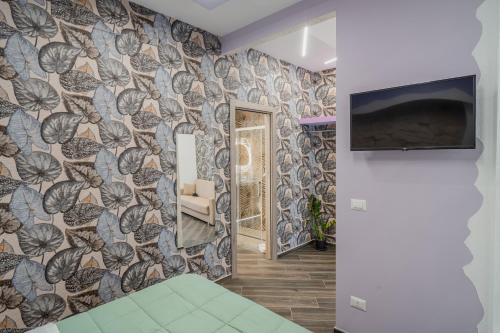 a living room with a wall covered in a wallpaper at LUXUITE Spa con Piscina o Jacuzzi in Alberobello