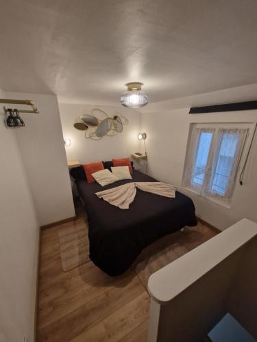 une chambre avec un lit noir et une fenêtre dans l'établissement LE PETIT TRIPLEX DES CARMELITES -COEUR HISTORIQUE, à Rouen