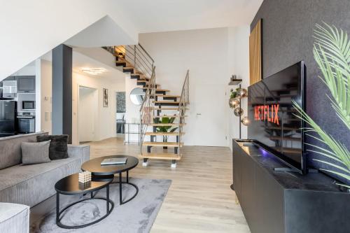 un soggiorno con un divano e un tavolo di Roof-Suite 02 I Aufzug I BBQ I WiFi I Balkon I TV a Rheda-Wiedenbrück