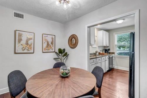 a kitchen and dining room with a wooden table and chairs at Modern 2 BR Condo - 2 block from San Marco in Jacksonville