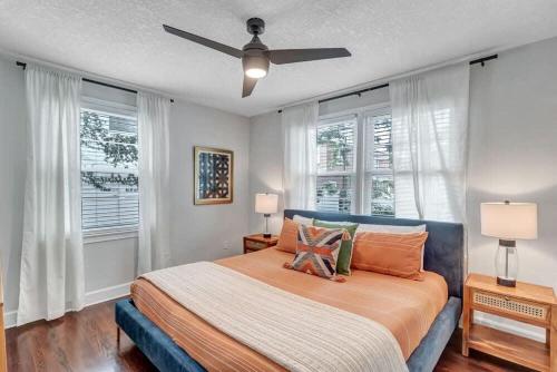 a bedroom with a bed with a ceiling fan at Modern 2 BR Condo - 2 block from San Marco in Jacksonville