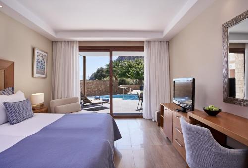 a hotel room with a bed and a television at Atlantica Aegean Park in Kolimbia