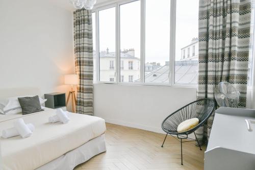 une chambre avec deux lits et une chaise et une fenêtre dans l'établissement Sacré-Coeur Modern 4BD with sauna for 10 guests!, à Paris