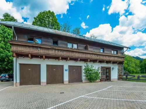 ブルック・アン・デア・グロースグロックナーシュトラーセにあるdetached modern holiday home with sauna in the Salzburgerlandの二つのガレージドアと駐車場のある建物