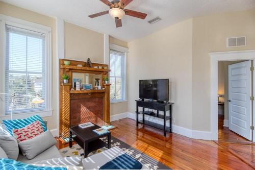 a living room with a couch and a tv at Open & Bright - 5 min drive to TIAA Bank field in Jacksonville