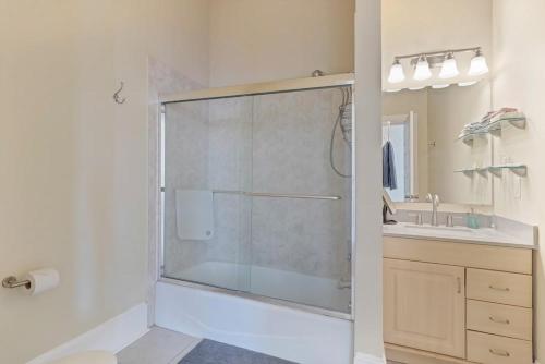 een badkamer met een douche en een glazen deur bij Open & Bright - 5 min drive to TIAA Bank field in Jacksonville