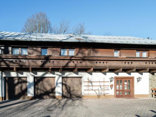 a building with a wooden roof with a door at detached modern holiday home with sauna in the Salzburgerland in Bruck an der Großglocknerstraße