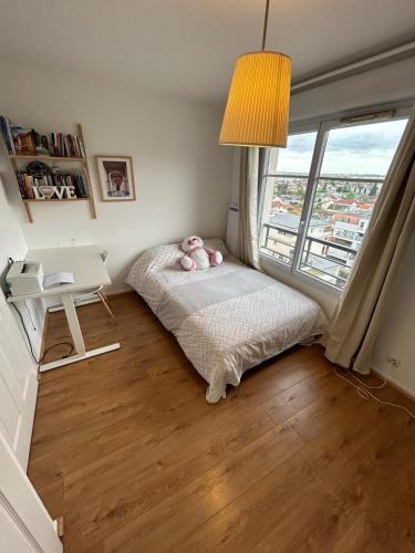 um quarto com uma cama, uma secretária e uma janela em Big duplex 15 min from Paris city center - Metro station Line 5 em Bobigny