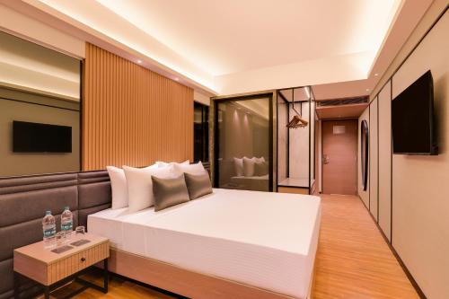 a bedroom with a large white bed and a television at Lemon Tree Premier, Malad, Mumbai in Mumbai