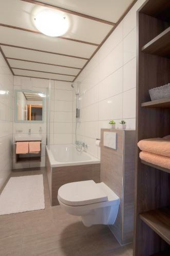a bathroom with a toilet and a bath tub at Appartements Rendl in Sankt Anton am Arlberg