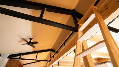 a ceiling fan in a room with a staircase at Hotel Re:Plug in Kochi
