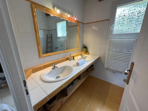 une salle de bain avec deux lavabos et un miroir dans l'établissement Pianiccia * Accés plage * proche Porto Vecchio, à Sari-Solenzara