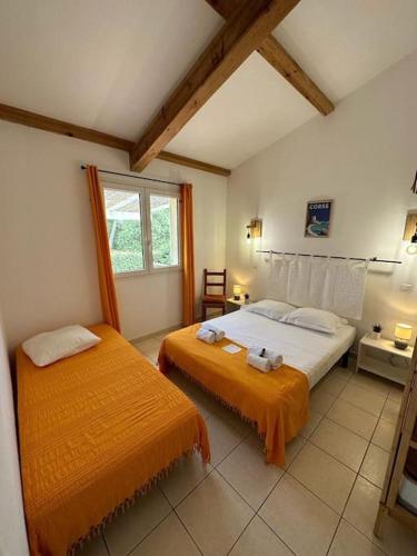 une chambre avec deux lits et une fenêtre dans l'établissement Pianiccia * Accés plage * proche Porto Vecchio, à Sari-Solenzara