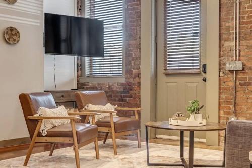 a living room with chairs and a flat screen tv at Modern, Insta-Worthy 2B Townhome in Walkable Springfield! in Jacksonville