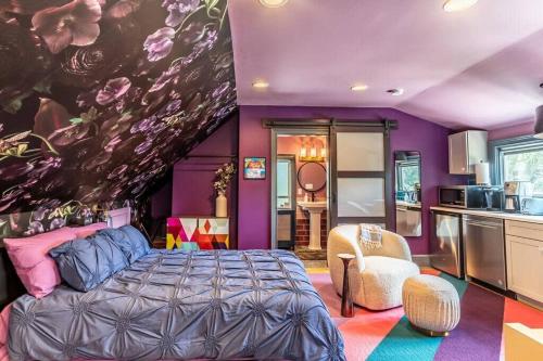 a purple bedroom with a bed and a kitchen at Studio loft w pool spa & gardens near downtown in Jacksonville