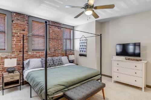 a bedroom with a bed and a brick wall at Modern, Insta-Worthy 2B Townhome in Walkable Springfield! in Jacksonville
