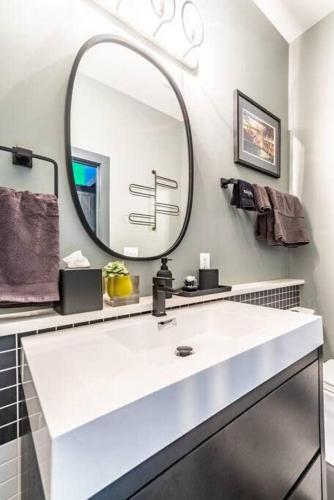 a bathroom with a white sink and a mirror at Unique studio w pool spa & gardens near downtown in Jacksonville